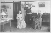 SA0144 - Mazella Gallup, Eldress Leila Taylor, and Rosetta were of the North Family. They are shown in a library. There is an ad on the back for other Shaker views., Winterthur Shaker Photograph and Post Card Collection 1851 to 1921c